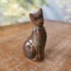 Pequena escultura de gato em cerâmica marrom